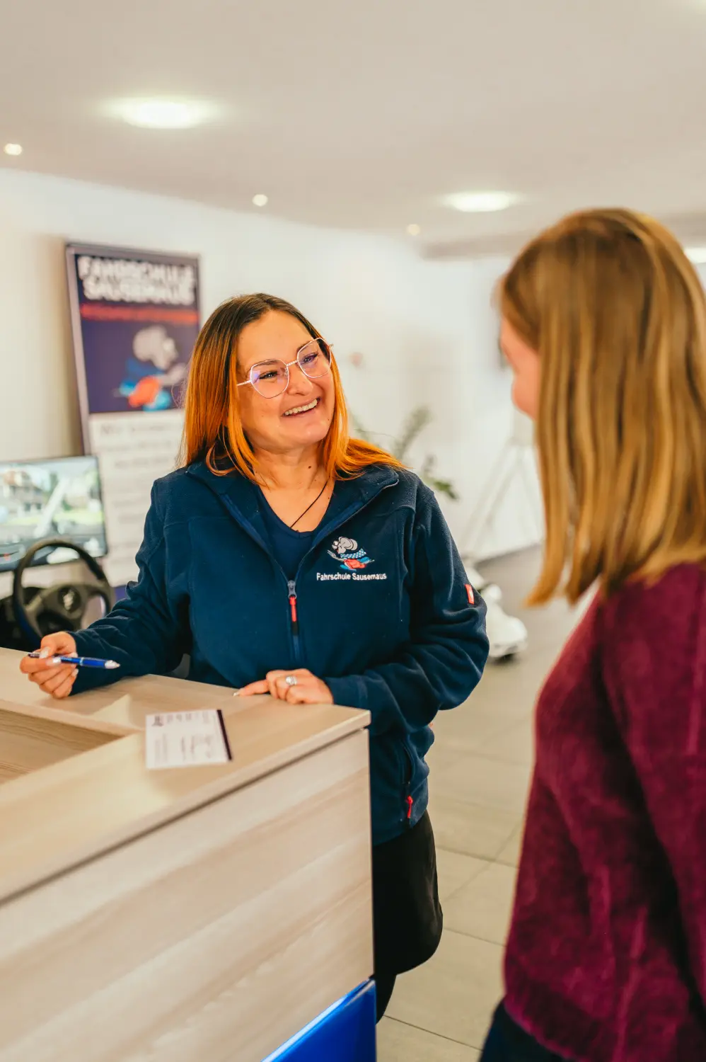 Fahrschule Sausemaus – eine Frau, die an der Rezeption einen Kunden betreut